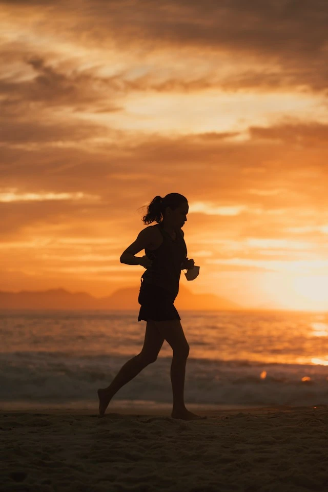 Une femme courant sur la plage.